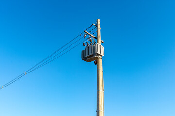 Obraz premium Electric power transformer on a pole with blue sky background in Brazil