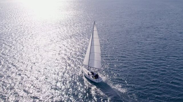 Aerial view of serene sailboat sailing in the blue Adriatic sea, Sibenik, Croatia.