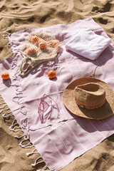 Straw hat, sunglasses, towel, bag on beach sand background. Aesthetic lifestyle, summer vacation concept. Sunbathing, beach party set, holiday picnic. Travel fashionable blog, social media, top view.