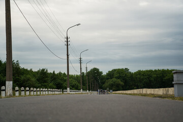 Fototapeta premium The road leading into the distance. The road along the sea where people walk. Lampposts along the road