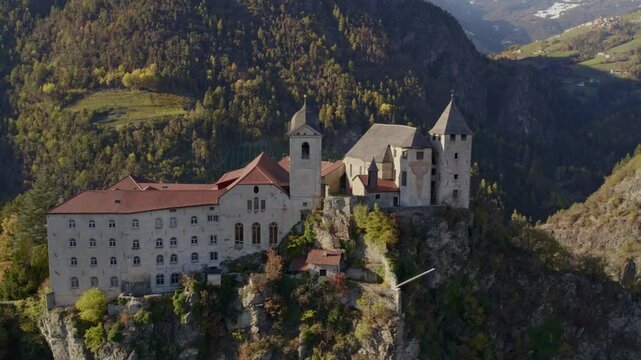 Aerial view of Monastero di Sabiona monastery with dolomites mountain peaks in autumn, Chiusa, South Tyrol, Italy.