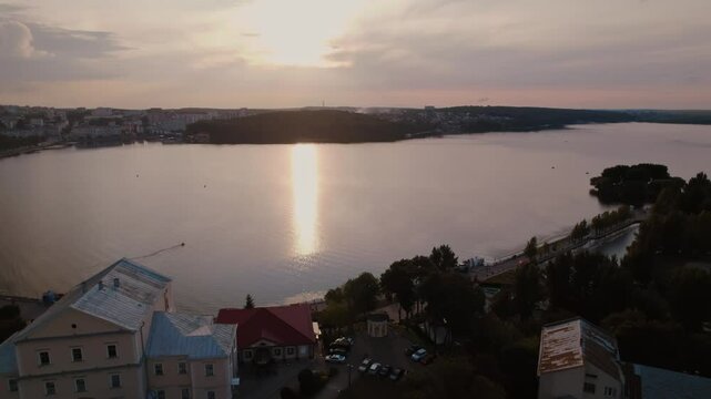 A beautiful drone shot showcases the peaceful charm of Ternopil, Ukraine as the sun sets over its serene landscape