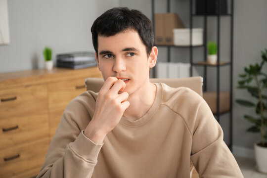 Portrait of embarrassed young man in office
