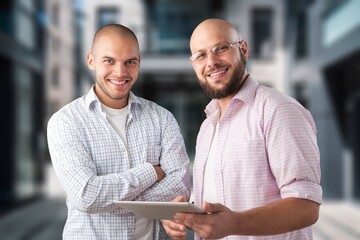 Two happy business colleagues standing near office,