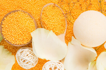 Composition of orange pearls, bath bombs and soap shavings, top view