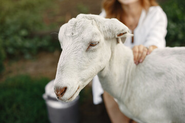 Putdoor portrait of young happy woman with goat
