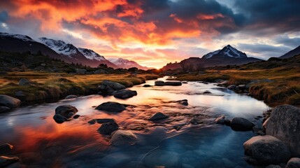 Serene mountain river reflecting the vibrant sunset.