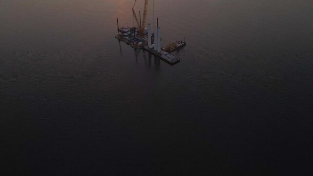 Aerial view of construction vessel with wind turbines at sunrise on the sea, Ijsselmeer, Netherlands.