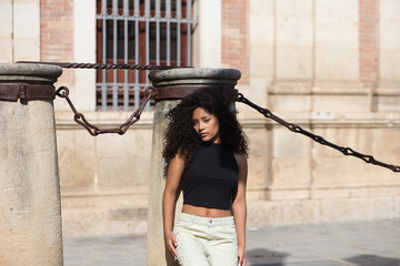 beautiful young latin woman with black and dark eyes and long curly hair with a sad expression...