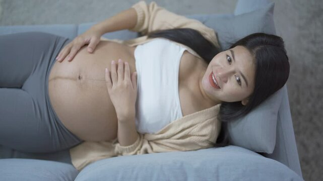 A Portrait of happy Asian pregnant woman in bedroom at home. Having a baby. Family people lifestyle. Love.
