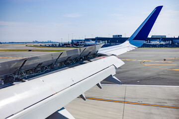 Airplane wing mechanics while landing in airport in sunny day