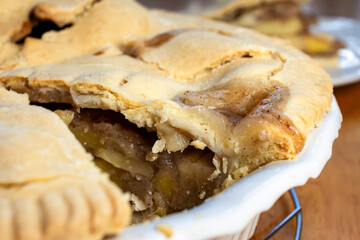 Making of an apple pie:  Cutting the pie.  The first piece of apple pie has been removed from the pie.  Closeup of filling.