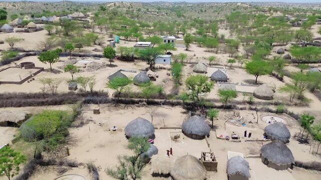 desert life in Tharparkar village, traditional desert houses and wooden huts, Amidst the world's largest desert, thar Desert landscape life aerial view.
