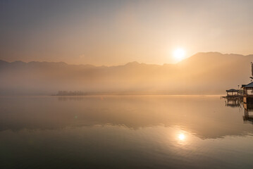 Obraz premium Panoramic landscape of Dal Lake nestled in Himalayas mountain range during sunrise on autumn morning from lake view point at Srinagar, Jammu and Kashmir, India.