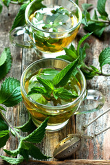 Two glass cups with fresh mint tea on wooden table