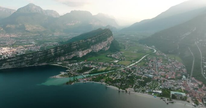 Aerial view of the cityscape of Riva del Garda on the shore of the lake in Italy. A tourist town among the beautiful natural rocks of the alpine Dolomites. High quality 4k footage