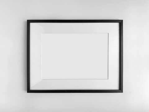 Fototapeta Black photo frame A4 size with White Photo Mat, horizontal artwork on a white wall, front view