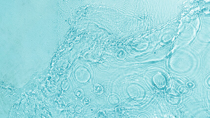Aqua  liquid colored clear water surface texture with splashes bubbles with copy space. Water waves in sunlight background.