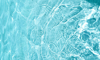 Aqua  liquid colored clear water surface texture with splashes bubbles with copy space. Water waves in sunlight background.