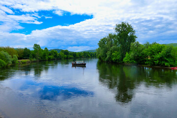 Obraz premium A Gabarre (traditional French barge) floating serenely down the River Dordogne in France 