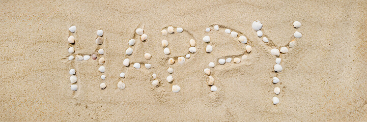 Shells spelling 'HAPPY' on sandy beach, symbolizing joy and celebration during summer vacations
