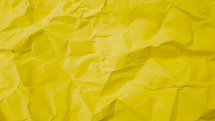 Crumpled yellow paper texture symbolizing frustration and creativity, ideal for problem-solving concepts and creative workspace background