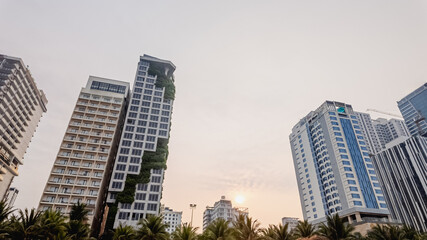 Obraz premium Skyscrapers in a modern urban cityscape at sunset, highlighting the concept of urbanization and metropolitan lifestyle