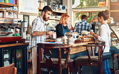 Barista, woman and cafe as waitress in small business with customer in restaurant or coffee shop. Working people, cafeteria and client for food service with entrepreneur in startup in New York City