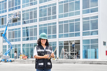 Industry engineer latin woman wearing uniform and safety helmet under inspection and checking construction. Industry, Engineer, construction concept.