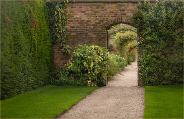 Pathway to an open door leading into a walled garden