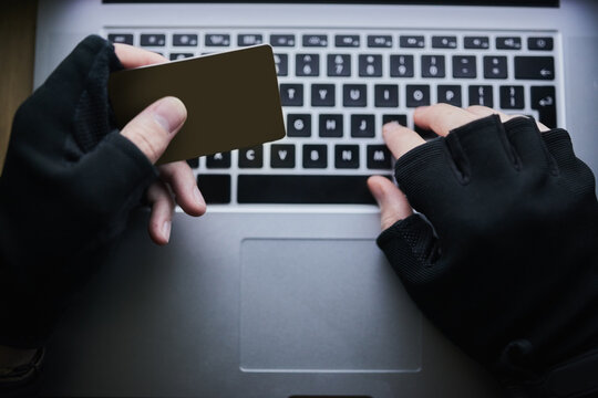 Typing, credit card and hands of hacker for cyber crime, financial fraud and cloning for identity theft or breach. Person, dark and online for hacking or malware attack, phishing and account takeover