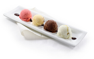 Helado de fresa, vainilla, chocolate y nata sobre bandeja. Strawberry, vanilla, chocolate and cream ice cream on a tray.
