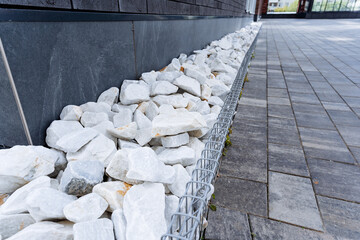 Next to the building, there is a distinctive ground layout with white stones on a brick path made...