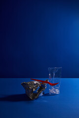 Crumpled Foil with Red Fork on Blue Background Representing Pollution