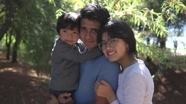 Father's Day, Mexican father with his children, a boy and a teenager outdoors