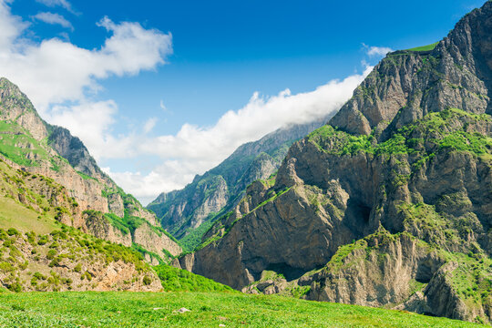 Steep vertical green rocks of the Karmadon gorge in the mountains of the northern Caucasus. Russia