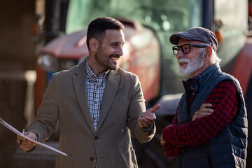 Bank agent talking to farmer on farm about contract