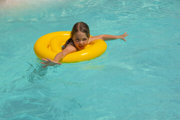 A 5-year-old girl swims in a pool with an inflatable circle
