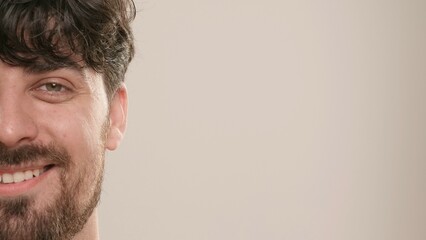 Obraz premium Young adult man looking at camera smiling, isolated on white background, close up shot. Natural beauty skin care concept.