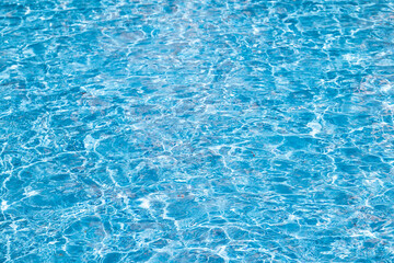 Blue swimming pool water surface and ripple wave background. Summer abstract reflection caustics in...