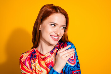 Photo portrait of lovely young lady hugging self look empty space dressed stylish colorful garment isolated on orange color background