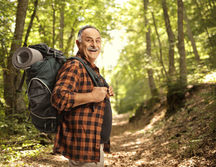 Cheerful mature hiker with a backpack smiling