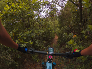 Riding a mountain bike on a single track in the middle of the woods rider point of view with a GPS...