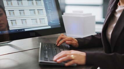 Skilled designer using 3D modeling tools to develop designs for buildings, create architectural plans at desk. Woman performing engineering task with CAD software app in a startup office.