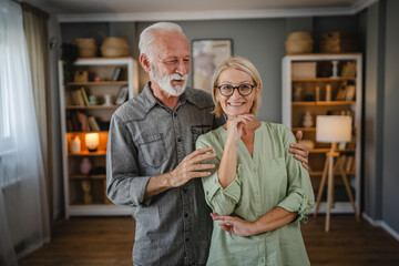 Portrait of senior husband and wife stand and hug each other