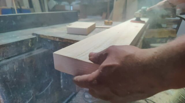 Shaping a Piece of Wood with a Sander in a Carpenters Workshop Footage.