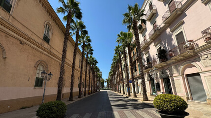 Fototapeta premium Avenue with palm trees and buildings. Via Mignogna in the city center of Taranto, Puglia, Italy 