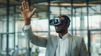 A businessman in a light gray suit interacts with a virtual reality headset by raising his hand, demonstrating immersive technology usage in a modern office environment.
