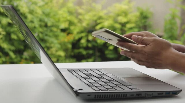 Cyber security 2FA login concept. Businessman working on laptop logging in on smartphone and modern device. The concept of remote work, freelancing, training, online shopping.