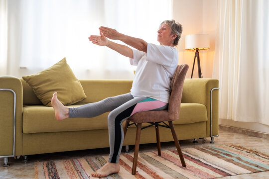 Senior caucasian woman doing yoga at home on chair